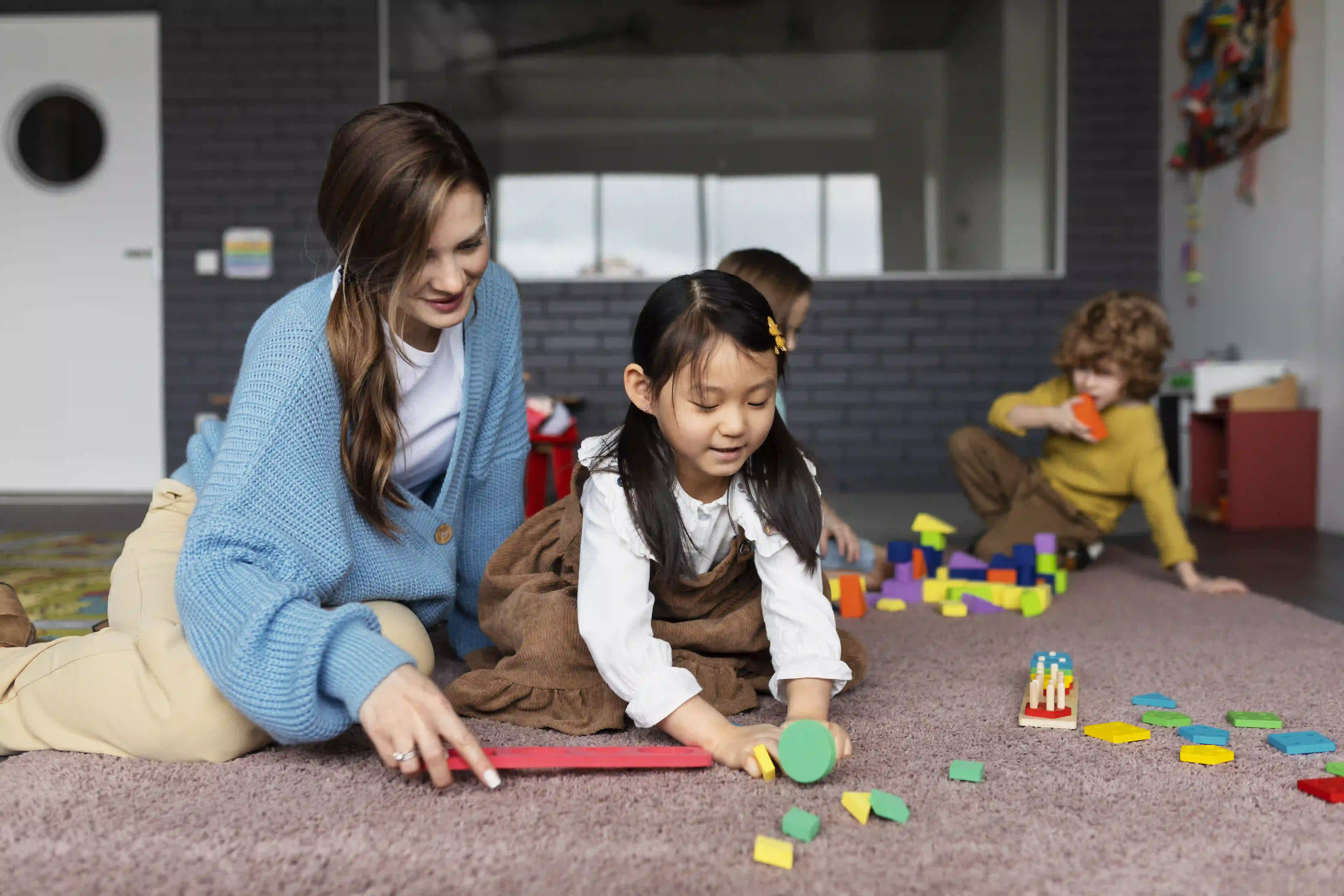 Caring teacher with children at Rainbow Kids